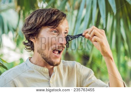 Happy Man With Black Mask On The Face. Photo Man Receiving Spa Treatments. Beauty Skin Care Concept.