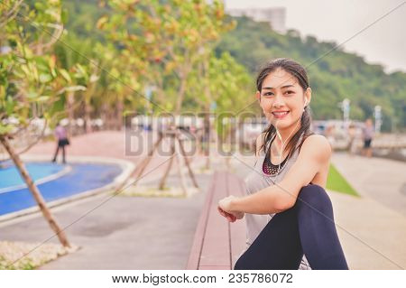 Sports Concept. Beautiful Girl Is Exercising On The Beach With Warm Up. Beautiful Girl Is Happy To E