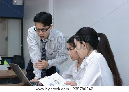 Group Of Young Asian Business People Working Together On A Laptop Computer At Office. Teamwork Brain