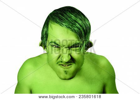 Young Angry Guy In The Image Of A Goblin With Green Skin, Grimaces. Isolated On White Background.