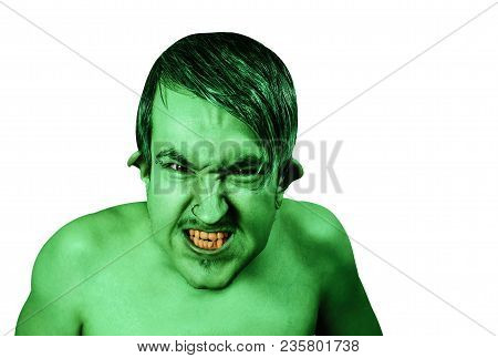 Young Angry Guy In The Image Of A Goblin With Green Skin, Grimaces. Isolated On White Background.