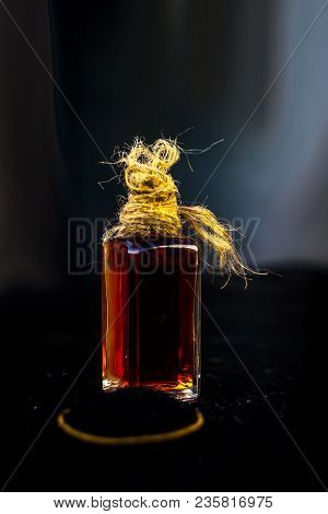 Close Up Of Oil Of Roman Coriander Or Kalonji Or Nigella Sativa On Wooden Surface In Transparent Bot