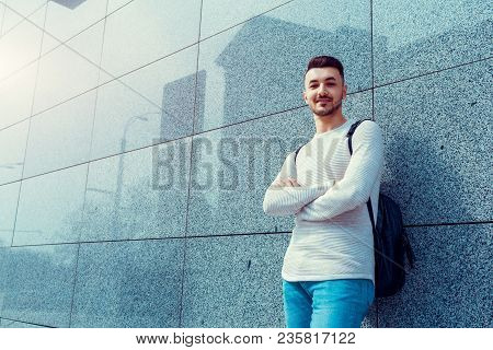 Arabian Student With Backpack Standing By The Wall Outside. Young Man With Backpack Waiting For Grou
