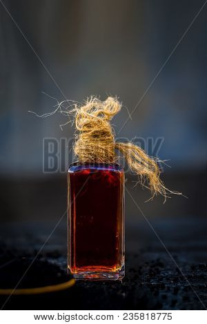 Close Up Of Oil Of Roman Coriander Or Kalonji Or Nigella Sativa On Wooden Surface In Transparent Bot