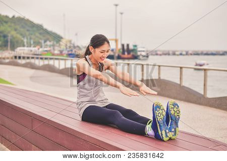 Sports Concept. Beautiful Girl Is Exercising On The Beach With Warm Up. Beautiful Girl Is Happy To E
