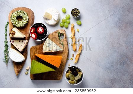 Assortment Of Hard, Semi-soft And Soft Cheeses With Olives, Grissini Bread Sticks, Capers, Grape, On