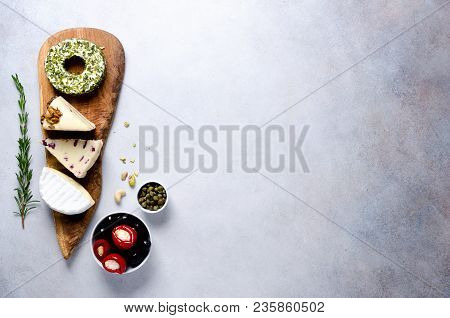 Assortment Of Hard, Semi-soft And Soft Cheeses With Olives, Grissini Bread Sticks, Capers, Grape, On