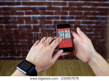 hands with phone in front of a brick wall. In the phone the design of the new wall.