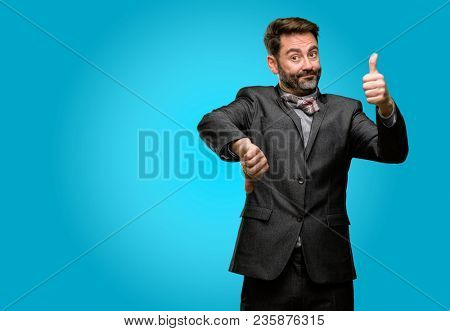 Middle age man, with beard and bow tie confused with thumbs up and down, trying to take a decision expressing doubt and frustration