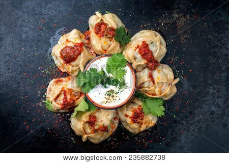 Traditional Kazakh manti steamed with mincemeat as top view on a plate with copy space right