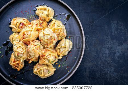 Traditional Kazakh manti steamed with mincemeat as top view on a plate with copy space right