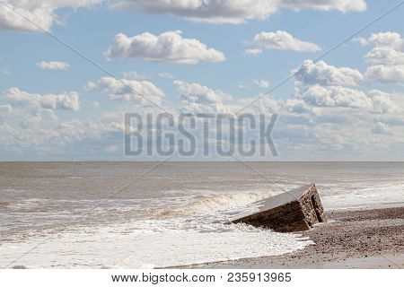D-day Normandy Landings. Pretty Coastal Landscape With Clouds And Partially Buried Ww2 Beach Defense