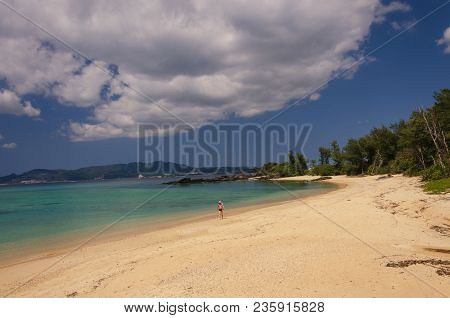 A Man Walking Away On The Beach Of Kouki In Nago On The Island Of Okinawa In Japan. Beautiful Turquo