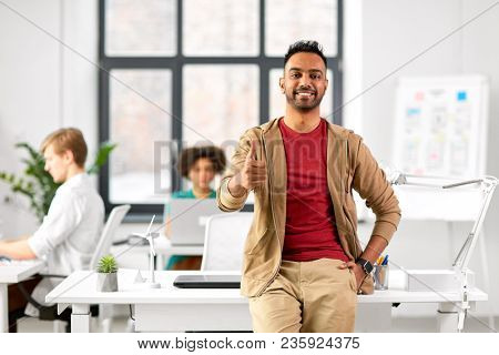 business and people concept - happy smiling indian man showing thumbs up at office