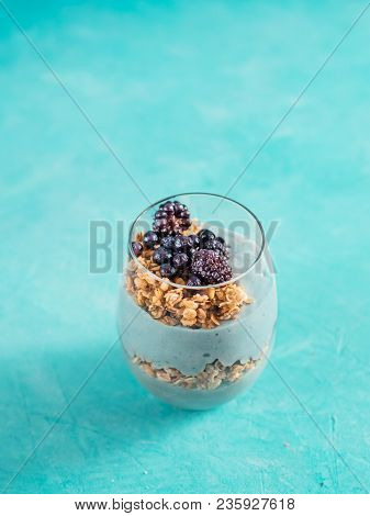 Triffle Dessert On Blue Tabletop With Copy Space. Blue Spirulina And Fruit Smoothie With Granola, Bl