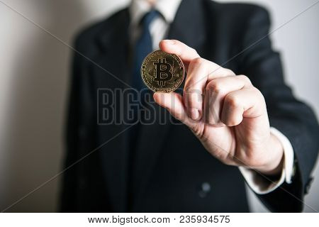 Golden Bitcoin In A Man Hand, Digitall Symbol Of A New Virtual Currency. Man Recived Money From Bitc
