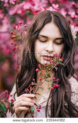 Portrait Of Beautiful Girl In A Pink Dress, Looking Down With Half Open Lips, Keeps On Hand A Twig W