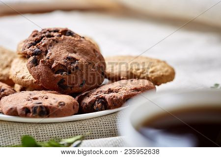 Side View Of A Plate Of Chocolate Chip Cookies On A White Plate Homespun Tablecloth Illuminated With