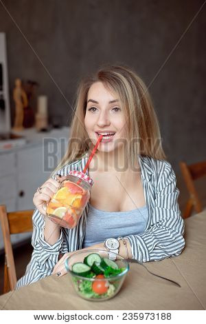 Happy Woman Sipping Fresh Summer Lemonade. Caucasian Young Girl 20-25 Years Old Sitting At The Table