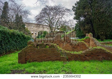 Remains Of Brick Walls In Garden Of Domus Aurea With Colosseum In Background