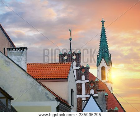 Red Roofs Of Old Houses In Skarnu Iela Street With St Johns Church In The Background Riga Latvia.