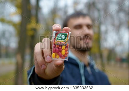 Kharkov, Ukraine - October 26, 2019: Young Man Shows New Tic Tac Hard Mints Package In Autumn Park. 