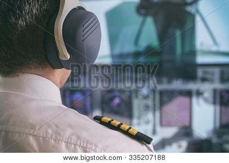 Close up of captain's epaulettes and headphones in the cockipt of commercial airplane
