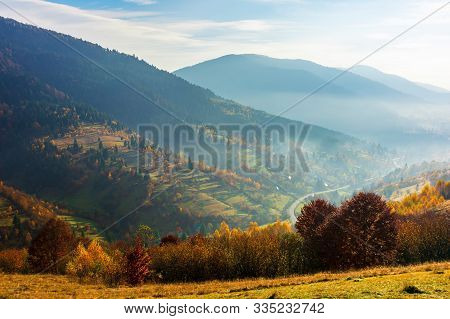 Carpathian Rural Area In Autumn. Wonderful Landscape In Mountains On A Hazy Day. Village In The Dist