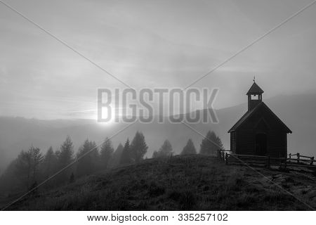 Moody Black And White Picture Of A Little Chapel On A Mountain Overlooking A Foggy Valley At Sunset 