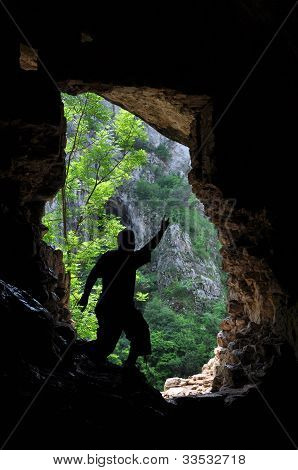 L'uomo in piedi davanti a un ingresso della grotta