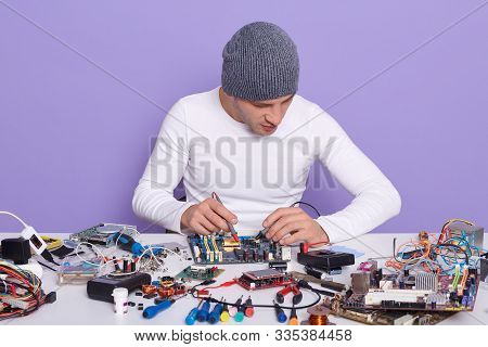 Electronic Engineer Measuring Voltage Of Electronic Curcuit Board With Help Of Multimeter, Working A