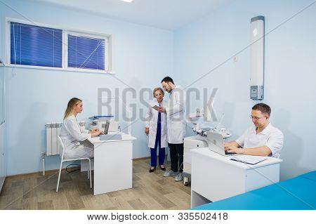 Group Of Doctors Involved In Serious Discussion With Medical Records