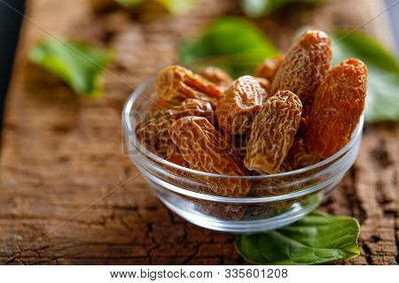 Dried Dates In Bowl. Dried Raw Organic Medjool Date Fruit And Green Mint In A  Bowl On Old Wooden Ta