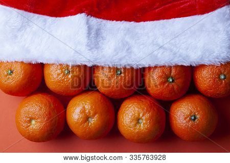 Christmas Tangerines In A Santa Hat On An Orange Background, Christmas Fruits, Festive Symbol