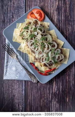 Beshbarmak Is A National Tatar Dish - Square Pasta With Boiled Meat And Onions. On A Black Backgroun