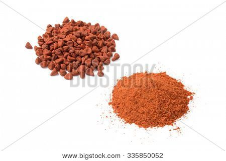 Heap of dried Annatto seeds and a heap of ground Annatto  powder isolated on white background