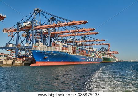 ROTTERDAM, THE NETHERLANDS - SEPTEMBER 21, 2019: Containers being unloaded from a huge cargo ship in the Euromax container terminal of the Port of Rotterdam. Vessel of CMA CGM French shipping company