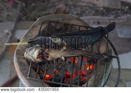 Grilled Batrachian Walking Catfish Or Airbreathing Catfish On Iron Grate Vintage Charcoal Stove.