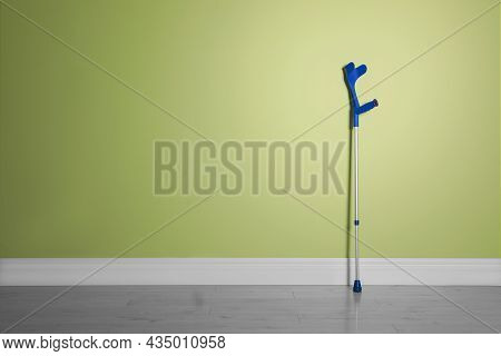 Elbow Crutch Near Light Green Wall. Space For Text