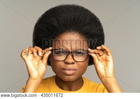 Young African Woman With Poor Eyesight Squinting Eyes Looking Through Eyeglasses Try To Read Text. B