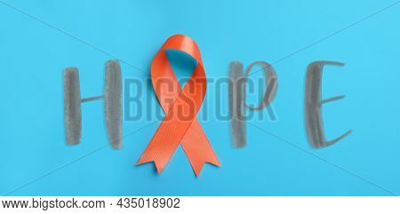 Orange Awareness Ribbon And Word Hope On Light Blue Background, Top View. Banner Design