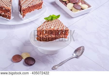 Chocolate Bisquit Cake With Icing On A White Plate
