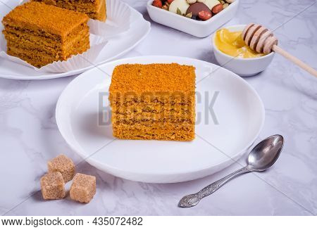 Honey Cake With Cream On White Plate On Marble Background