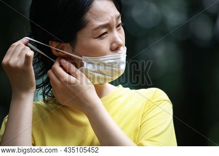 A Woman Wearing A Mask And Having A Sore Ear