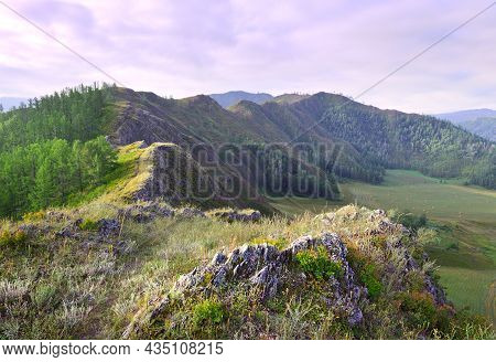 Sharp Rocks On A Mountain Top Under A Blue Cloudy Sky. Siberia, Russia
