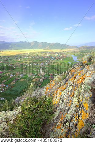 The Edge Of A Cliff Above A Mountain Valley Under A Blue Cloudy Sky. Siberia, Russia
