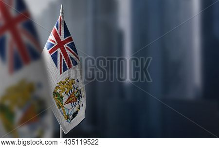 Small Flags Of British Antarctic Territory On A Blurry Background Of The City