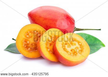 Ripe tamarillo fruits with slices and tamarillo leaves isolated on a white background.