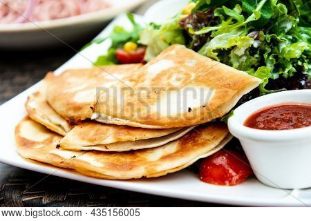 Delicious Mexican beef quesadillas with fresh lettuce and guacamole sauce