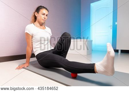Athletic Caucasian Slim Woman Doing Myofascial Self-massage Of The Thigh And Gluteus Muscles In A Ma